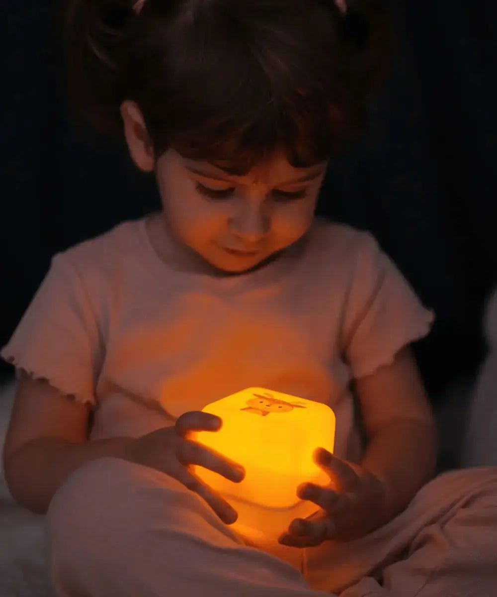 Vue de la veilleuse Cube B Finley le Faon dans les mains d'un enfant