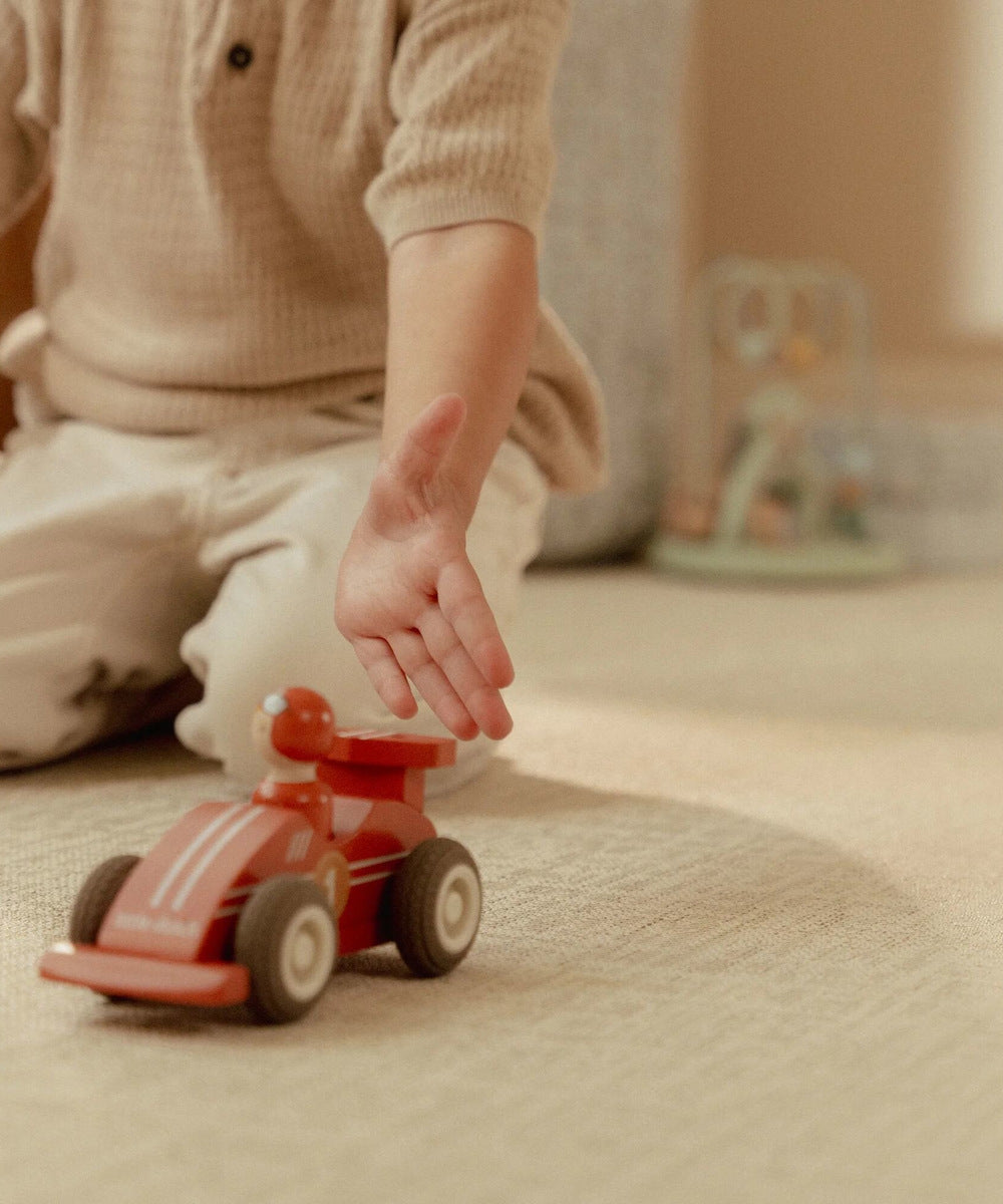 Enfant poussant la voiture de course rouge Little Dutch