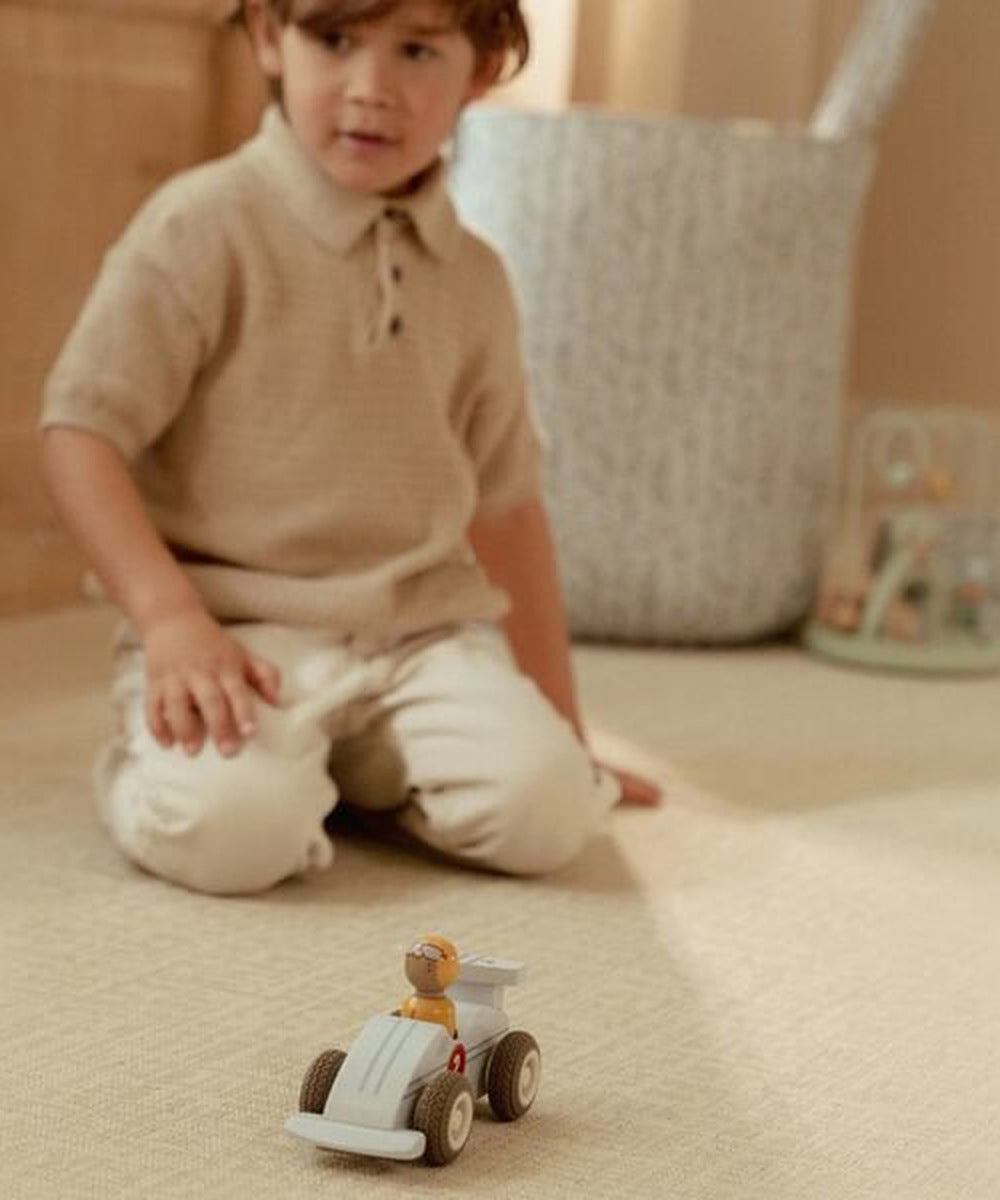 Enfant observant une voiture de course sur le sol